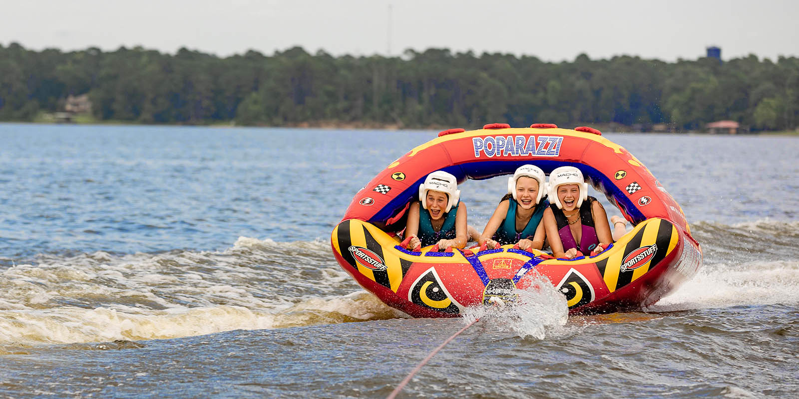 Campers laughing together on a lake tube ride at Camp Cho-Yeh